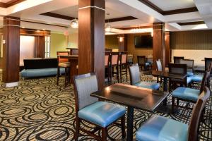 グリーンフィールドにあるHoliday Inn Express & Suites Greenfield, an IHG Hotelのテーブルと椅子、テレビ付きのレストラン