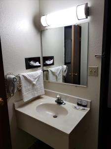 a bathroom with a sink and a large mirror at Value Inn & Suites Salina in Salina