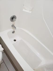 El baño incluye bañera blanca con lavamanos. en Value Inn & Suites Salina, en Salina