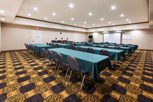 a conference room with tables and chairs and a screen at Holiday Inn Express Hotel & Suites Kilgore North, an IHG Hotel in Kilgore