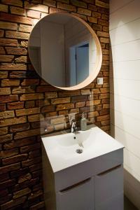 a bathroom with a white sink and a mirror at Apartament Centrum XL - Komfortowe Noclegi in Piaseczno
