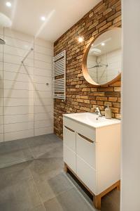 a bathroom with a white sink and a mirror at Apartament Centrum XL - Komfortowe Noclegi in Piaseczno