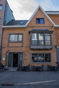 un edificio con tavoli e sedie di fronte ad esso di Logies De blauwe regen a Beveren