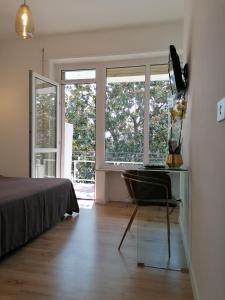 a bedroom with a bed and a desk and windows at Guest House Arte in Rome