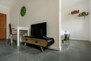 a living room with a television and a table and a bed at Apartamenty Centrum M - Komfortowe Noclegi in Piaseczno