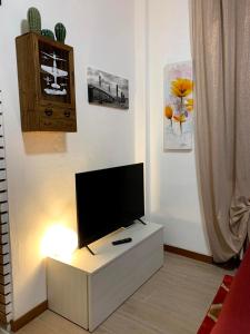 un salon avec une télévision à écran plat sur une armoire blanche dans l'établissement Appartamento “La Corte”, à Paderno Dugnano