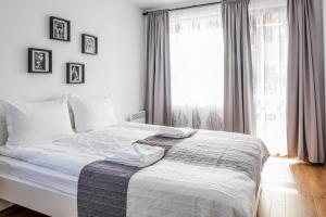 a bed in a bedroom with a large window at City View Apartment With 2 Bedrooms and Free Garage in Blagoevgrad