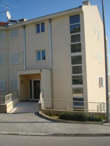 a large white building with a parking garage at Apartment Z&E in Trogir