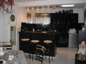 a kitchen with a black counter and stools at Apartment Casa Molino in Mogán