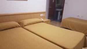 two beds in a hotel room with two beds at Hostal El Altet in El Alted