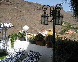 a balcony with pillows and a street light and a mountain at Apartment Casa Molino in Mogán