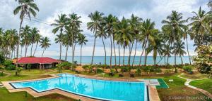 ein Resort mit einem Pool und Palmen in der Unterkunft Sanmali Beach Hotel in Marawila