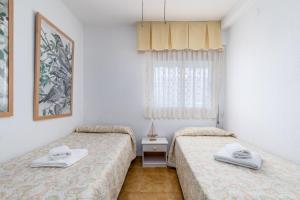 a room with two beds and a window at Travel Habitat Playa Almadraba Benicassim in Benicàssim