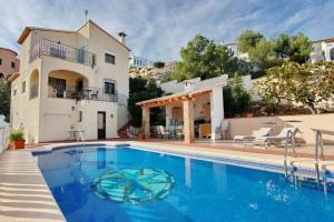 a large swimming pool in front of a house at Lovely villa with wonderful views in Pego