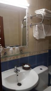 a bathroom with a sink and a toilet and a mirror at Hostal El Altet in El Alted