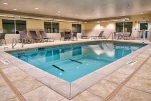 una gran piscina con sillas y mesas en Holiday Inn Express & Suites Tulsa NE, Claremore, an IHG Hotel, en Claremore