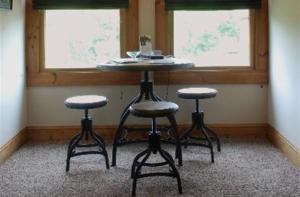 a table and two stools in a room with two windows at Shirley's Bed And Breakfast in Roanoke