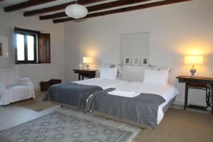 a white bedroom with two beds and a chair at Casas Herdade do Convento da Serra in Almeirim +125 photos