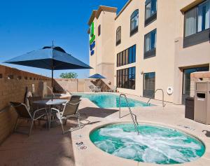 uma banheira de hidromassagem com uma mesa e cadeiras ao lado de um edifício em Holiday Inn Express & Suites Oro Valley-Tucson North, an IHG Hotel em Oro Valley