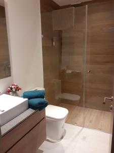 a bathroom with a toilet and a glass shower at &ONE Quito Parque La Carolina Alquiler por días in Quito