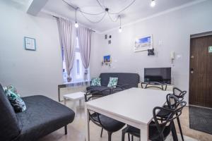 salon z kanapą, stołem i krzesłami w obiekcie Apartament Izaaka w Krakowie
