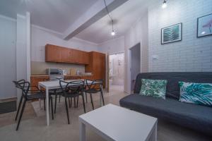 a living room with a couch and a table and a kitchen at Apartament Izaaka in Krakow