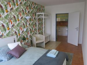 ein Schlafzimmer mit einem Bett und einer Tapete in der Unterkunft Apartmány Nad ZOO in Pilsen