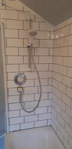 a shower with a hose attached to a brick wall at Bodhi Tree Cottage - Grove Road Cottages in Stratford-upon-Avon +14 photos