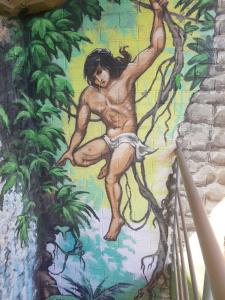 Mural człowieka wspinającego się na drzewo na ścianie w obiekcie Маугли - дом-сказка у моря w Odessie