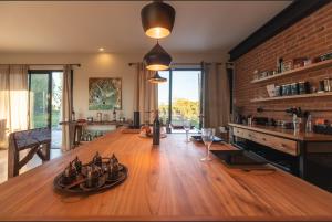 a kitchen with a large wooden table with wine glasses at Casa Vinyet in General Alvear