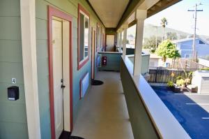 une terrasse couverte vide d'une maison avec une porte dans l'établissement Cayucos Sunset Inn, à Cayucos