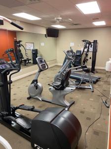 a gym with several cardio bikes and tread machines at Northfield Inn Suites and Conference Center in Springfield