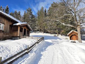 a snow covered path next to a cabin at Gamlestugu Greivjord Fjellgard in Tuddal
