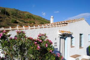 a white house with flowers in front of it at Cortijo Lagar de Luisa in Borge