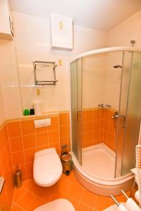 an orange bathroom with a shower and a toilet at Apartments Villa Ana 1 in Cavtat