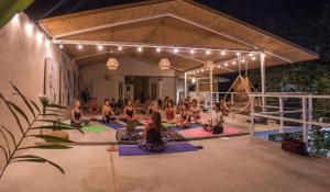 a group of people sitting in a yoga class at Selina Santa Teresa South in Santa Teresa Beach