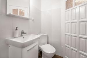 a white bathroom with a toilet and a sink at CITYSTAY Plac Walowy Gdansk in Gdańsk
