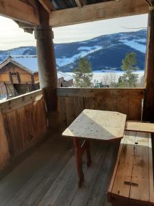 a bench on the porch of a cabin with a view at Gamlestugu Greivjord Fjellgard in Tuddal