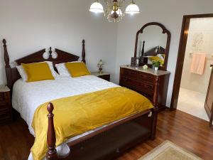 1 dormitorio con cama, tocador y espejo en Casa da Tia en Poutena