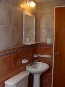 a bathroom with a sink and a toilet and a mirror at Guardalaola in Las Grutas