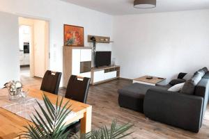 a living room with a couch and a table at Modernes Ferienhaus an der Kapelle in Emsbüren