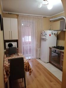a kitchen with a table and a white refrigerator at Вишенка in Vinnytsya