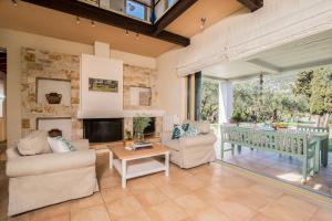 a living room with two couches and a fireplace at Villa Lithia in Áno Korakiána