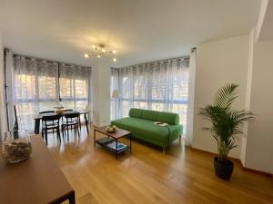 uma sala de estar com um sofá verde e uma mesa em Beach Luxury Apartment em Valência