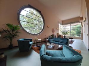 a living room with blue couches and a large window at Villa Gotti Charming Rooms in Bologna