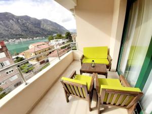 a balcony with chairs and tables and a view of a river at Maritimo di Cattaro****Lux Apartment with Garage in Kotor