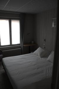 
a bedroom with a bed and a window at A Casa in Nieuwpoort
