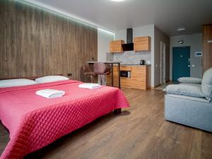 a bedroom with a red bed and a couch at Solo Apartment Kamenskaya in Kyiv