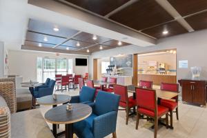 um restaurante com mesas e cadeiras e uma cozinha em Holiday Inn Express & Suites Tavares, an IHG Hotel em Tavares