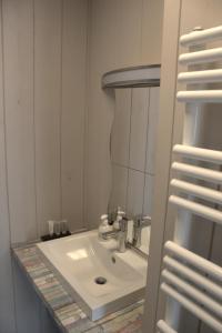 
a white sink sitting under a mirror in a bathroom at A Casa in Nieuwpoort
